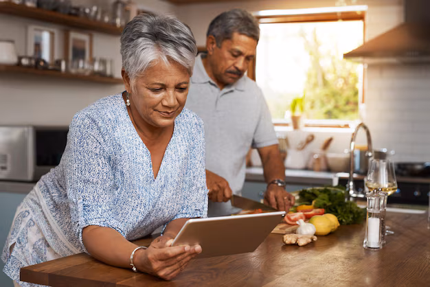 Tablet with nutrition app next to healthy meal - Senior couple tablet and cooking in kitchen with healthy food ...