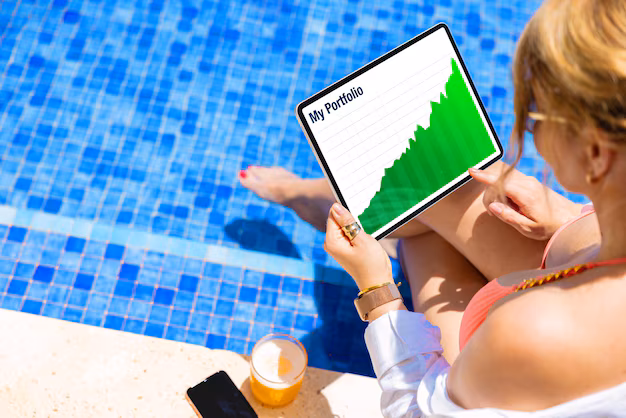 investment portfolio chart on tablet - Woman sitting by the pool and looking at her investments portfolio ...