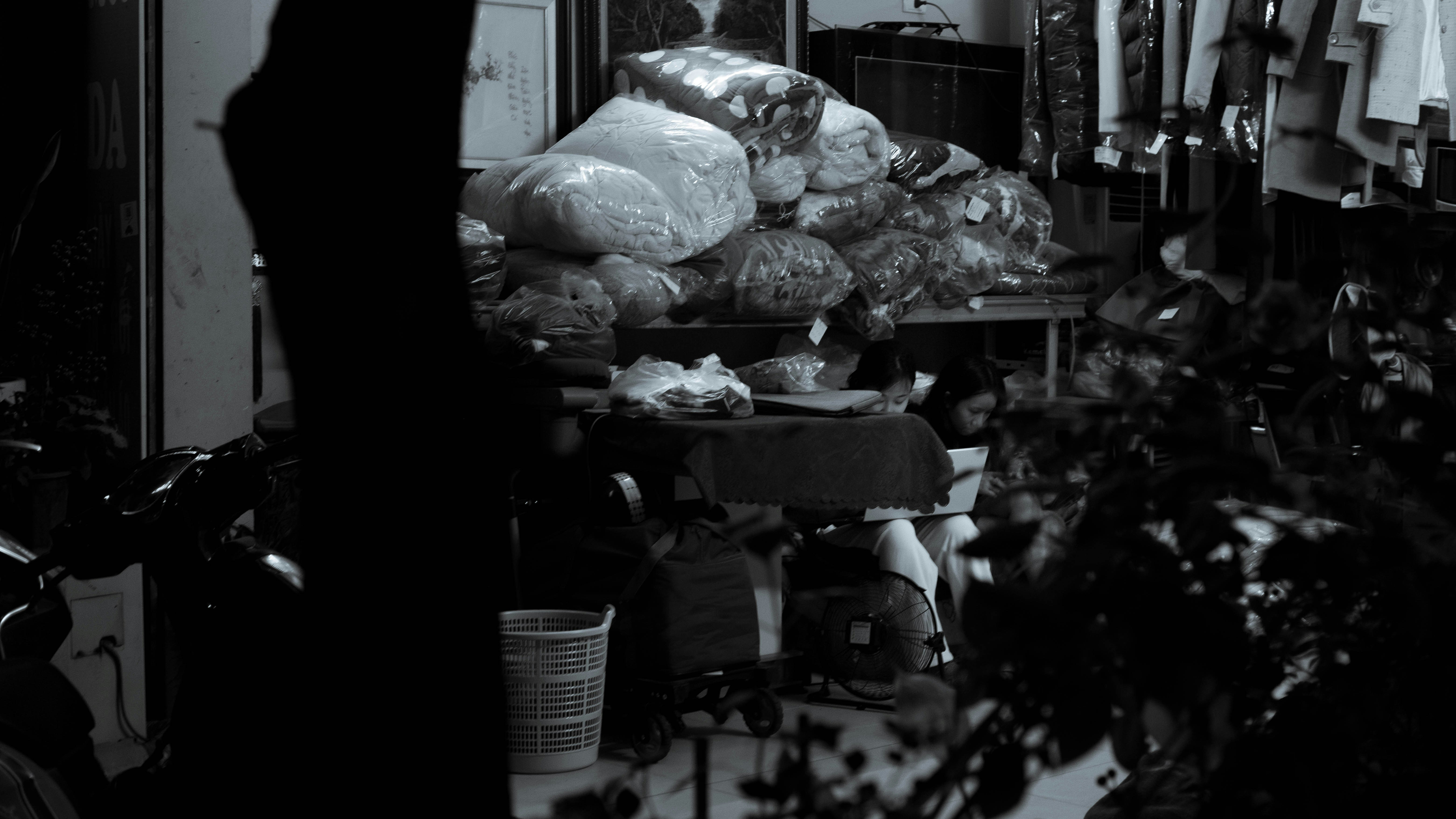 Person sorting recycling in kitchen - a black and white photo of a person sitting at a table