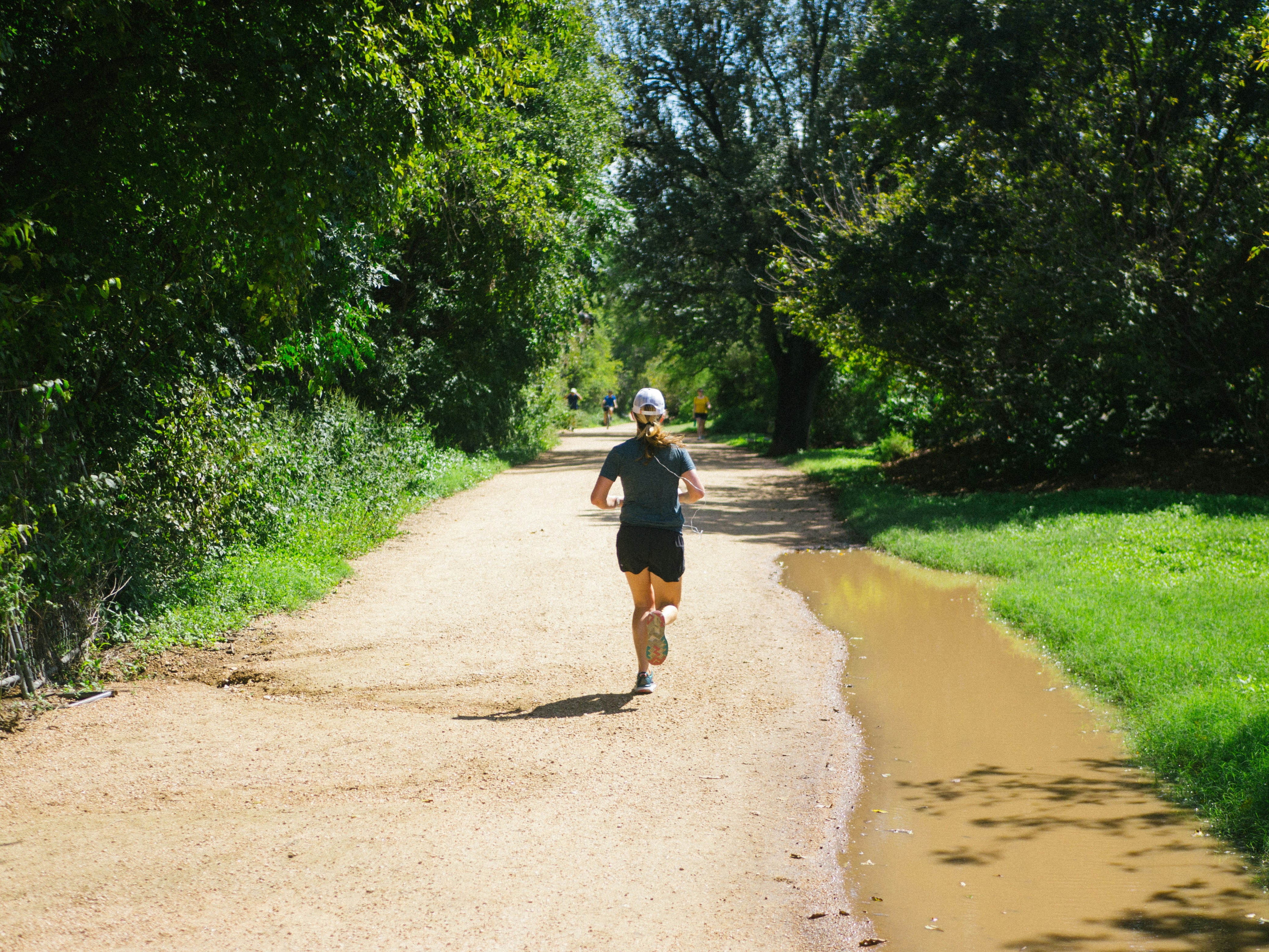 man running outdoors with biometric data overlay - Running on hike and bike trail in Austin TX