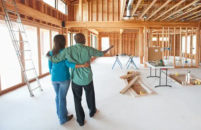 couple reviewing home renovation loan documents with contractor - Construction Loans | Virginia Credit Union